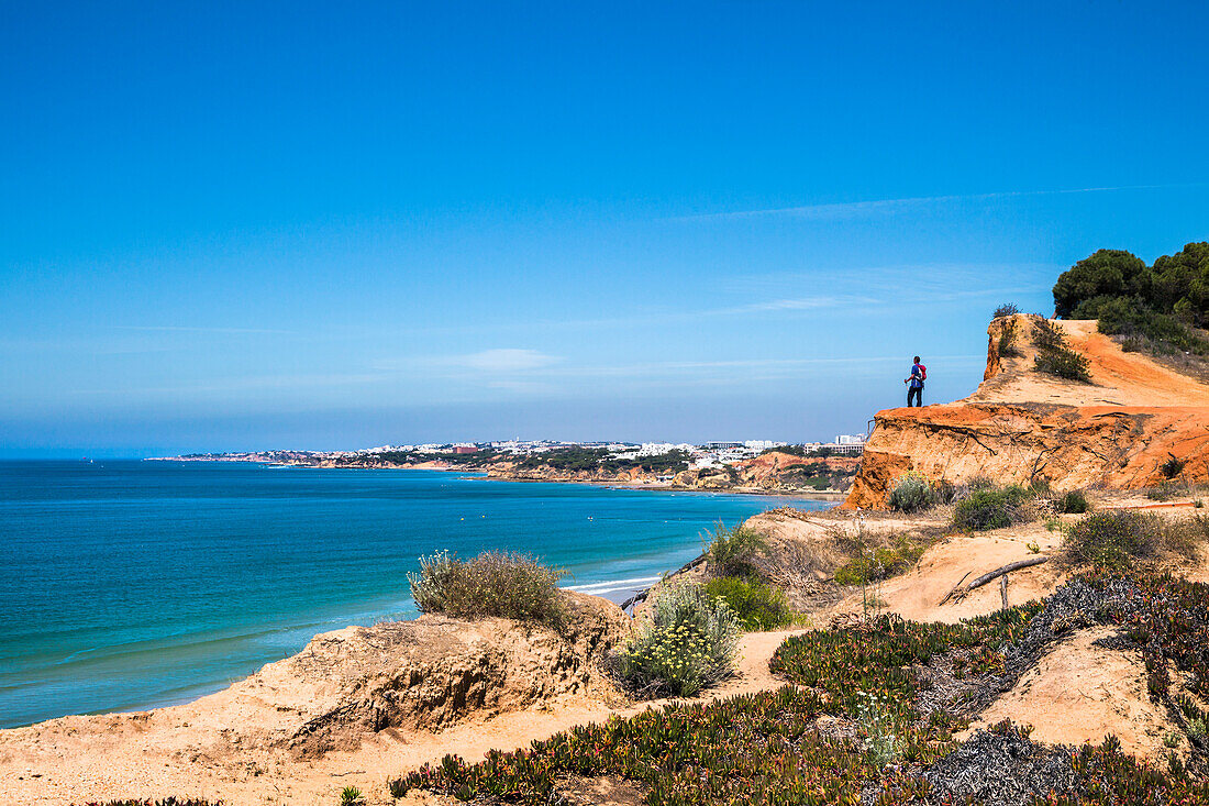 Hiker on cliffs, Praia de Falesia, Albufeira, Algarve, Portugal