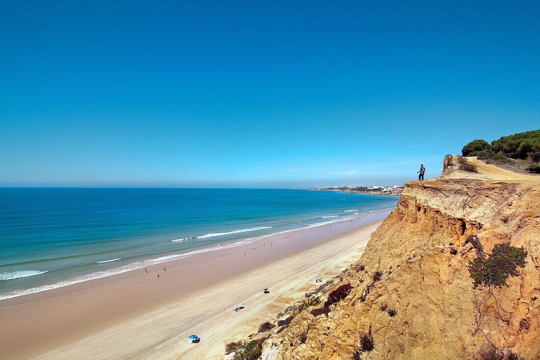 Hiker on cliffs, Praia de Falesia, Albufeira, Algarve, Portugal