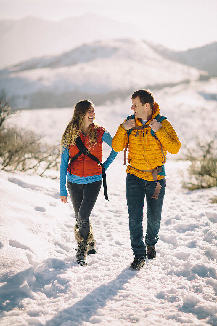 A young couple hikes in the wintry mountains.