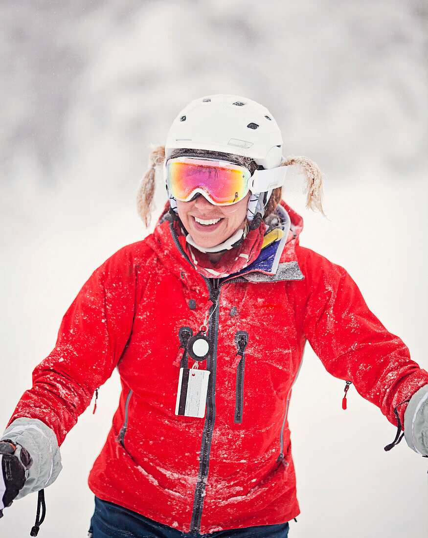 A female skier with her braids tucked into her goggle straps.
