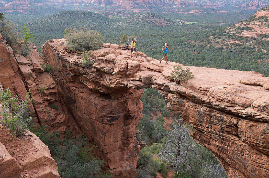 Hikers on the Devil's Bridge in Red Rock-Secret Mountain Wilderness Area outside Sedona, Arizona May 2011.  The Devil's Bridge is an easy two-mile hike with spectacular views.