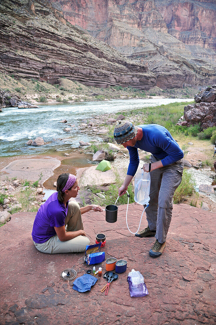 Hikers cook dinner on a cliff-pinched patio above camp and the Colorado River near Deer Creek Falls in the Grand Canyon outside of Fredonia, Arizona November 2011.  The 21.4-mile loop starts at the Bill Hall trailhead on the North Rim and descends 2000-fe