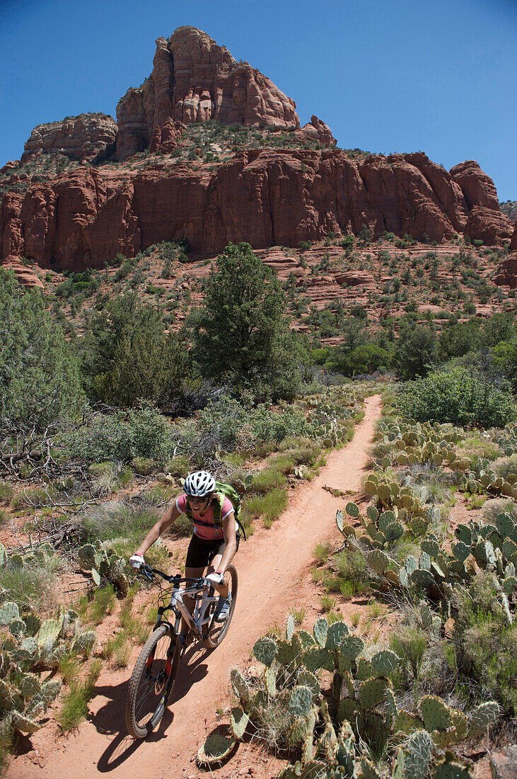 Woman rides the Submarine Rock Loop in South Sedona, Arizona. The trail has everything from slickrock to single track to stairs that lead to Submarine Rock.