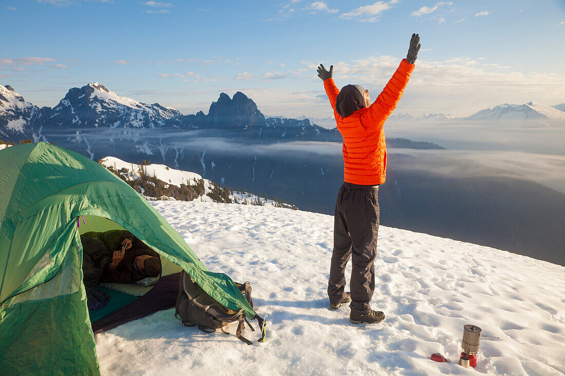 A climber celebrates the beautiful day he woke up to while camping in the mountains of British Columbia, Canada.