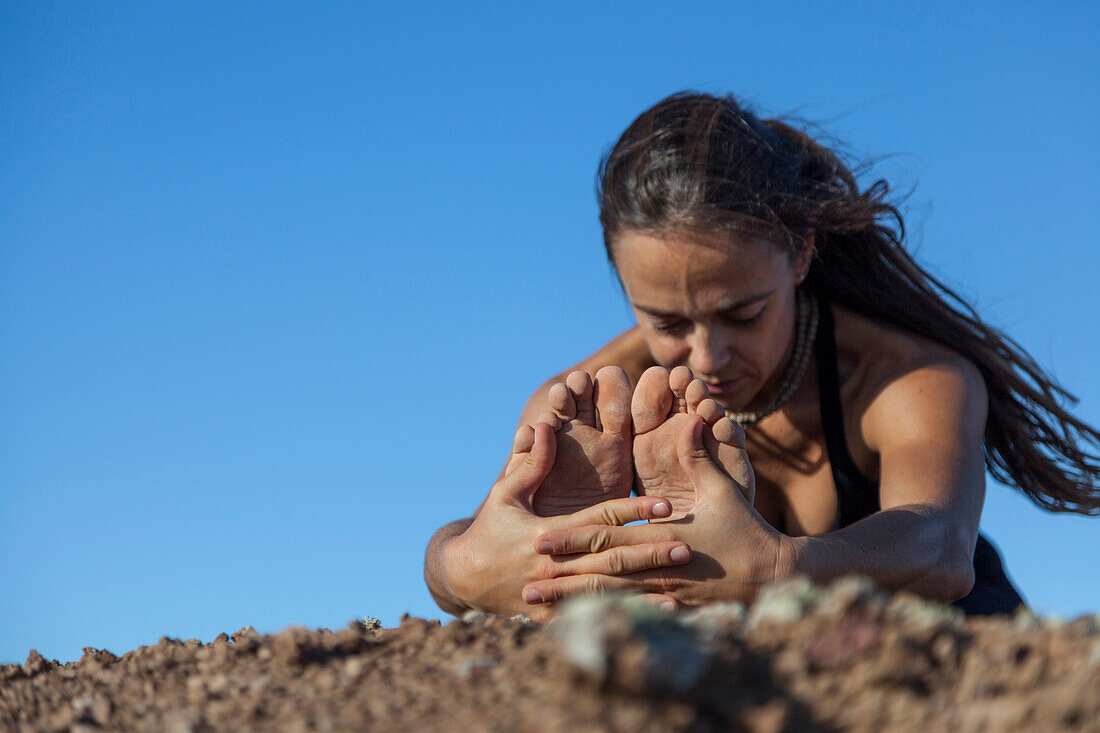 Girl doing yoga on the top of a volcano in Fuerteventura, Canary Islands