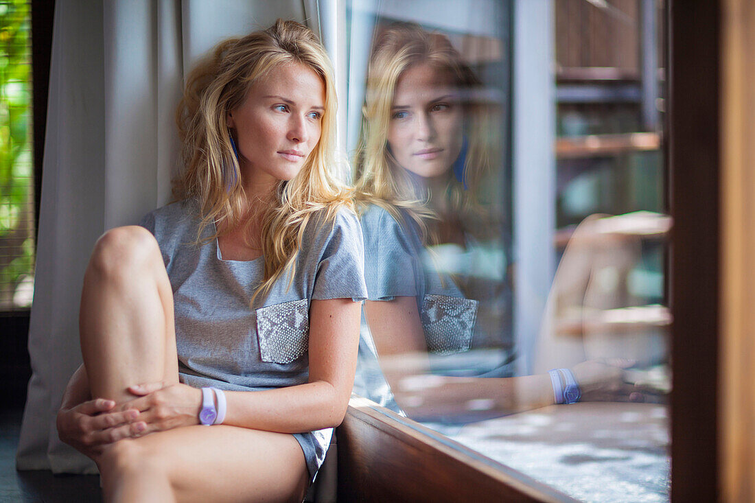 Young woman looking out the window.