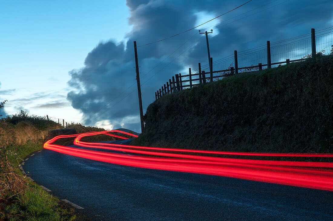 Car streaks on the narrow hillside roads of Dingle