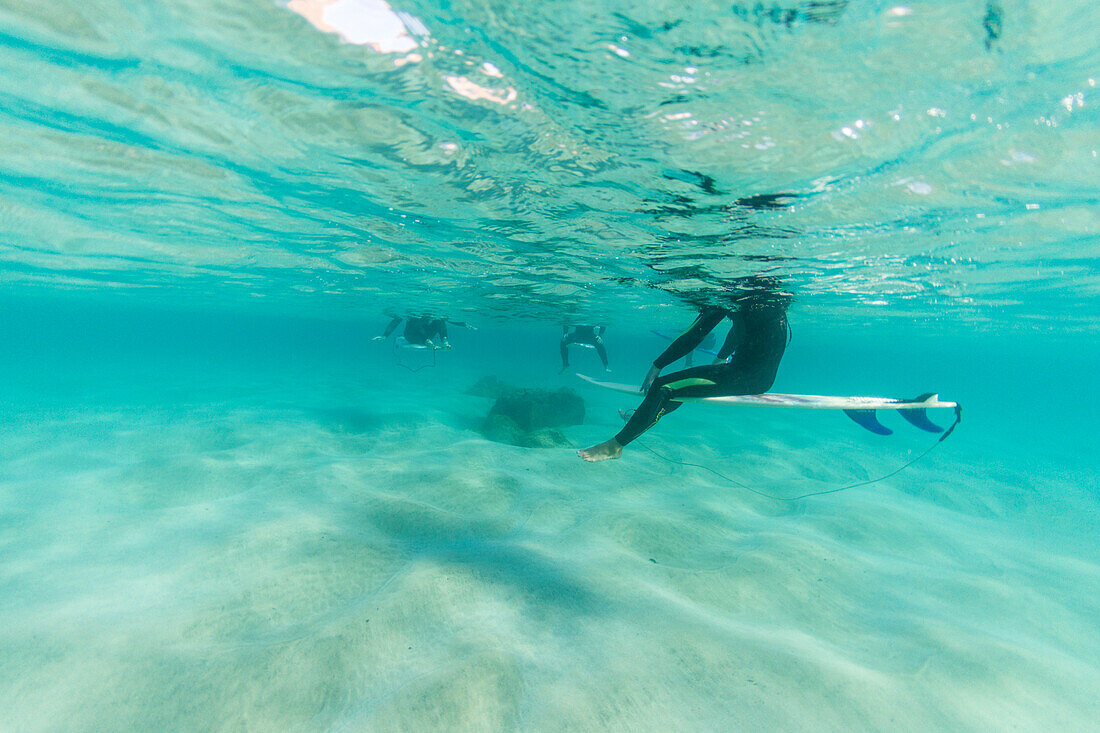 Surfer sitting on his board in the water