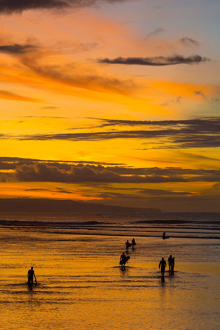 Surfers at sunrise.