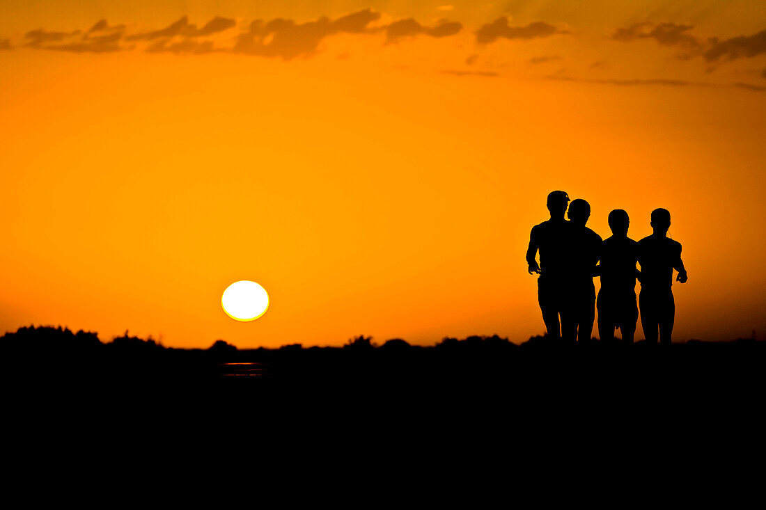 Four runners are silhouetted by the rising sun on 17th June 2011, Ahal Province, Turkmenistan.