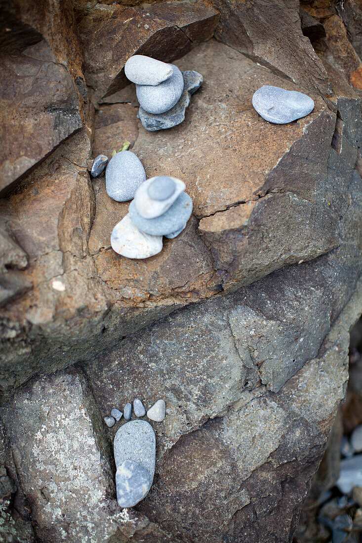 Small cairns sit atop the rocky coastline in New England.