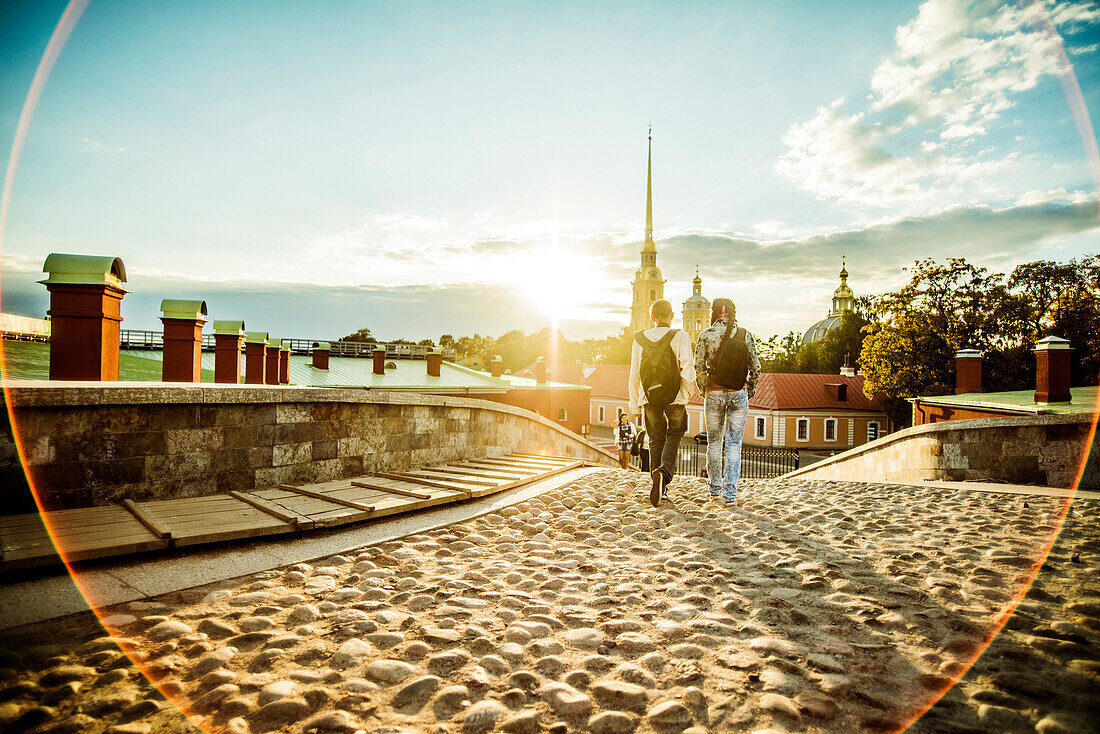 Caucasian tourists walking on cobblestone Leningrad street, Leningrad, Russia