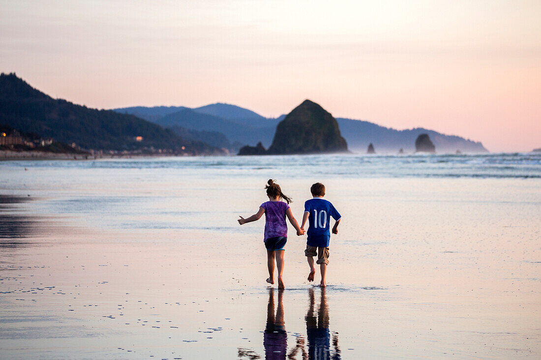 Caucasian children walking on beach