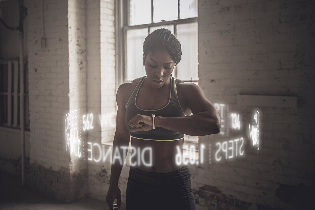 Virtuelle Wörter umkreisen schwarze Sportlerin, die ihren Fitness-Tracker überprüft