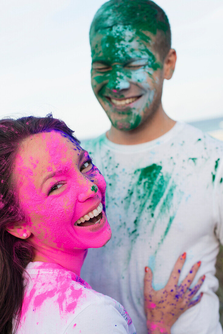Caucasian couple splattered with paint powder