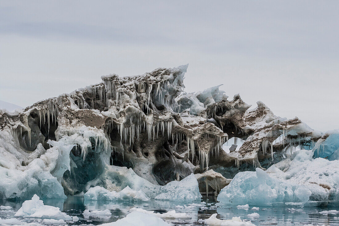 Iceberg with moraine material and icicles at Booth Island, Antarctica, Polar Regions