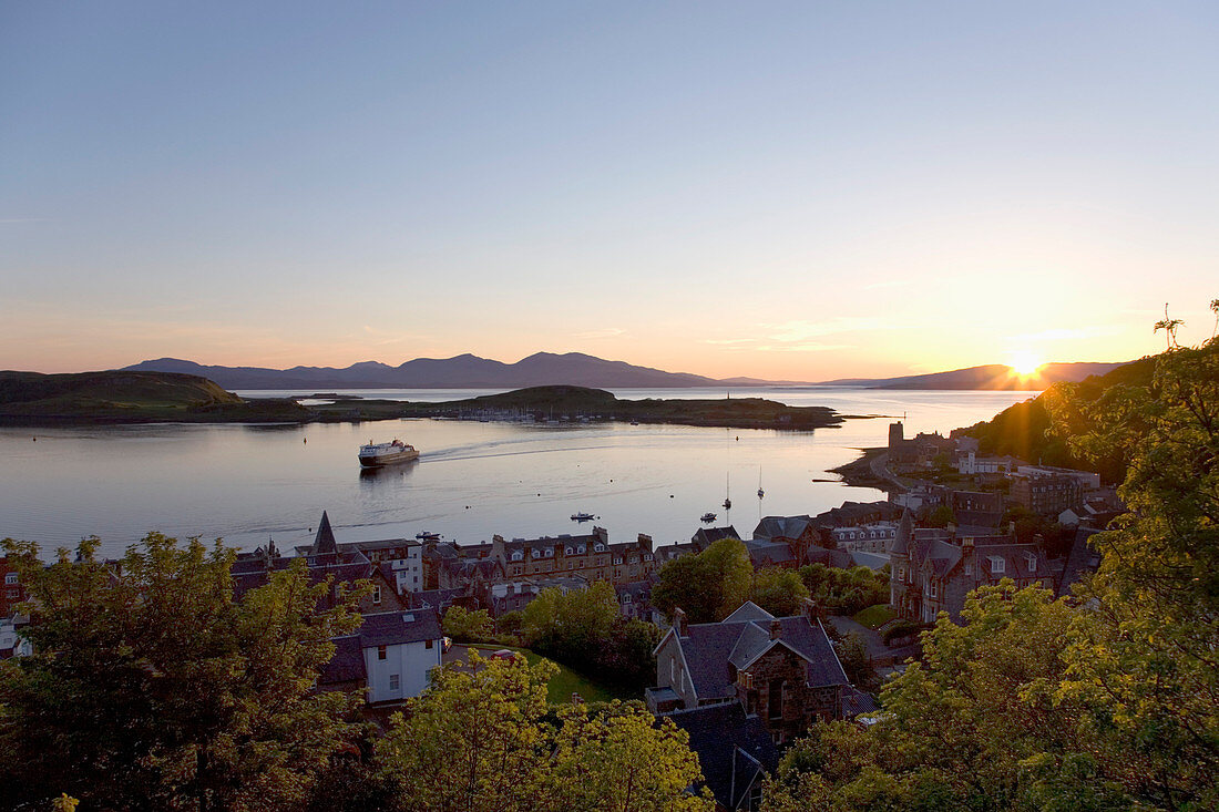 View over Oban Bay from McCaig's Tower, sunset, ferry coming into port, Oban, Argyll and Bute, Scotland, United Kingdom, Europe