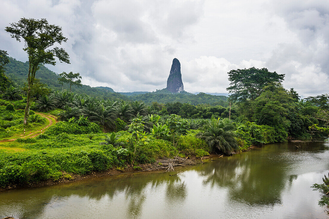 River flowing before the unusal monolith, Pico Cao Grande, east coast of Sao Tome, Sao Tome and Principe, Atlantic Ocean, Africa