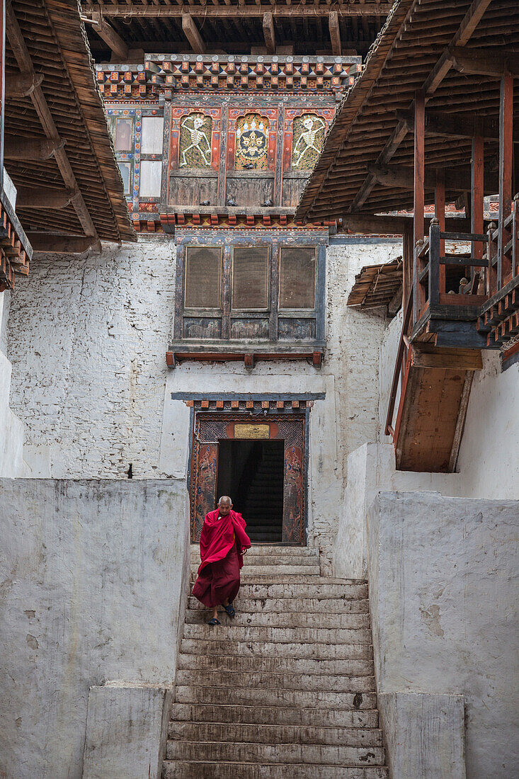 Tibetan monk comes out from Punakha Dzong, the second oldest and most majestic dzong in Bhutan, Asia