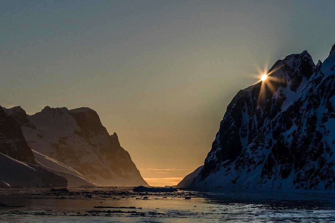 Sunset over Booth Island in the waters of the Lemaire Channel, Antarctica, Polar Regions