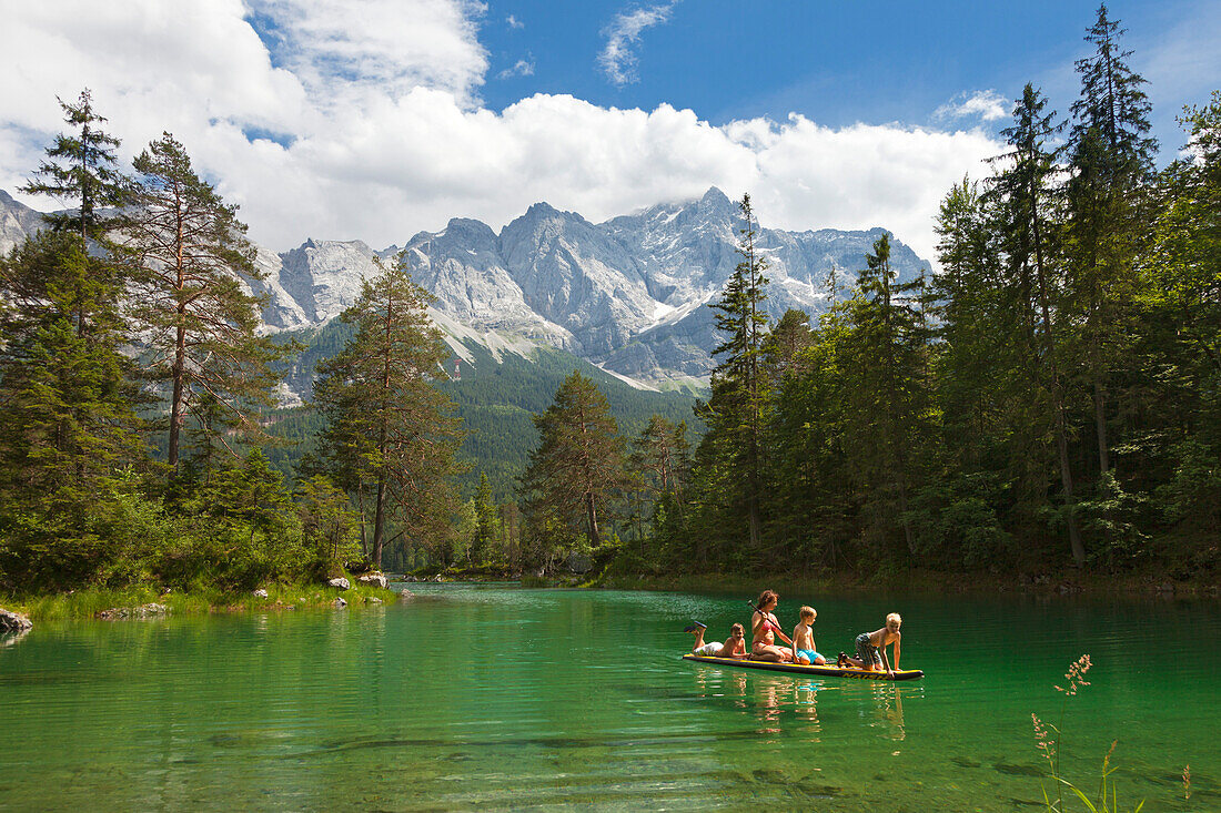 Woman paddling with children at Eibsee, Zugspitze, near Garmisch-Partenkirchen, Werdenfels region, Bavaria, Germany