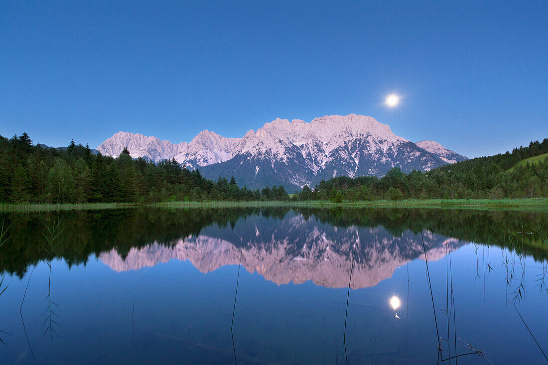 Full moon reflecting at Luttensee, view to Karwendel, near Mittenwald, Werdenfels region, Bavaria, Germany