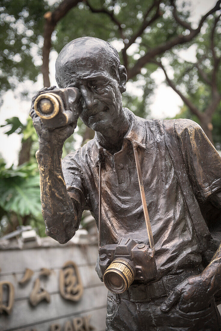 bronze statue of tourist filming and taking photographs in the colonial quarter at Downtown Guangzhou, Guangdong province, Pearl River Delta, China