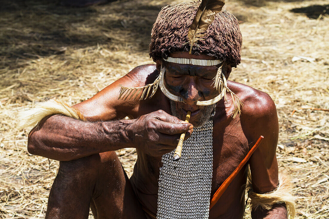 Dani man smoking rolled tobacco, Obia Village, Baliem Valley, Central Highlands of Western New Guinea, Papua, Indonesia