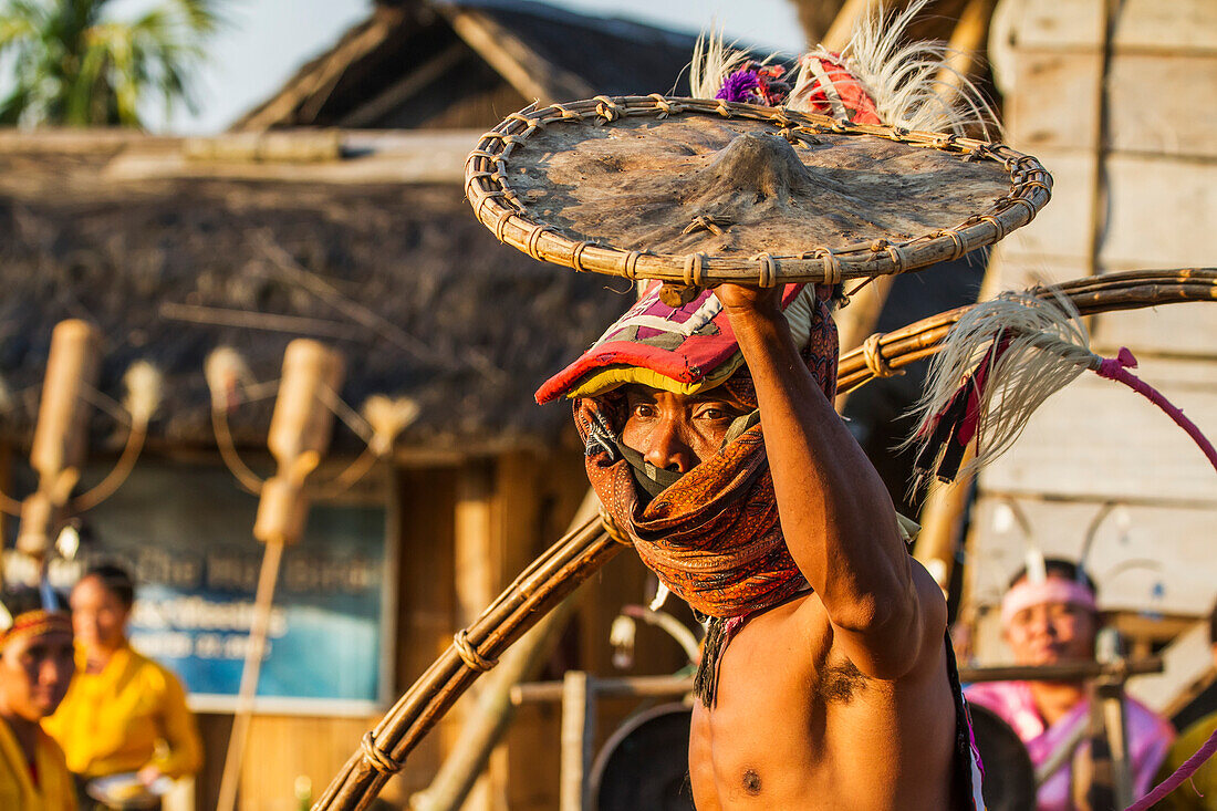 Manggarai man wearing a traditional headdress wrapped with cloth wielding a shield and bamboo whip in a caci, a ritual whip fight, Melo village, Flores, East Nusa Tenggara, Indonesia