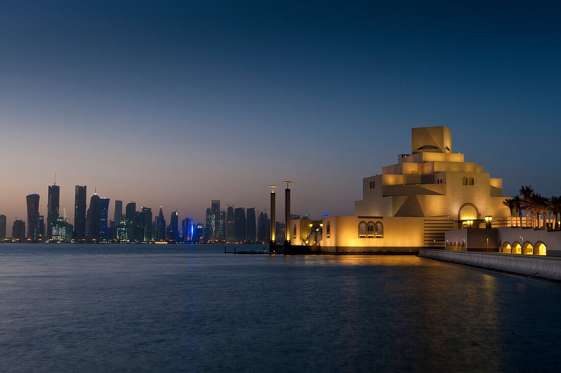 Museum of Islamic Art at dusk with modern city skyline behind, Doha, Qatar