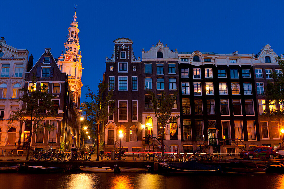 Gabled houses at dusk with the spire of the Zuiderkerk church behind, Amsterdam, Holland