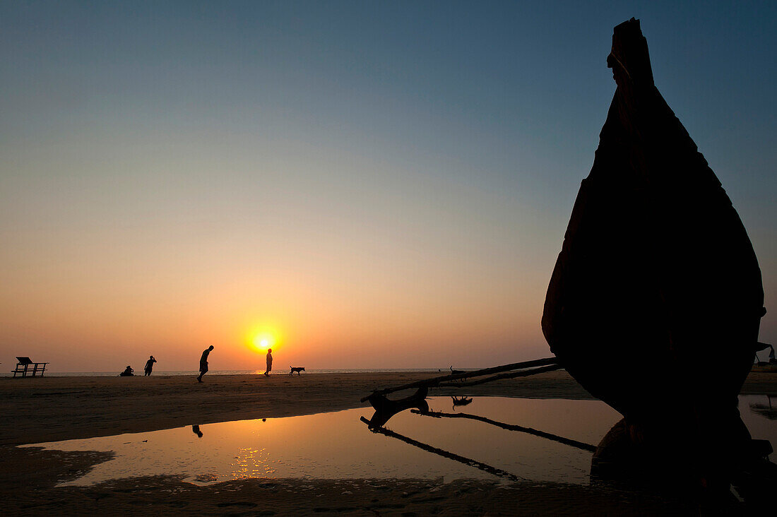 Bow of old boat on beach at dusk, Goa, India