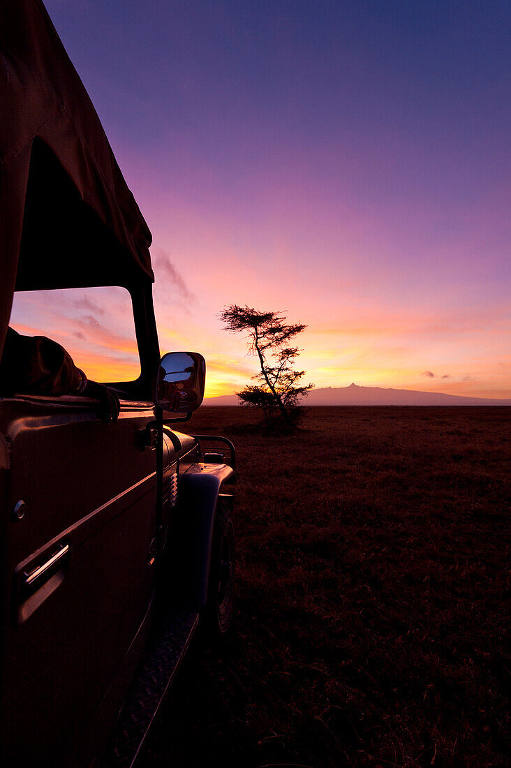Silhouette of guide in 4x4 in front of Mt Kenya at dawn, Ol Pejeta Conservancy, Kenya