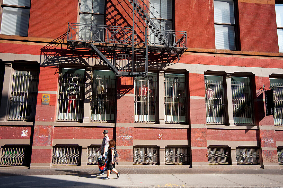 Couple Passing By An Apartments Building In Tribeca, Manhattan, New York, Usa