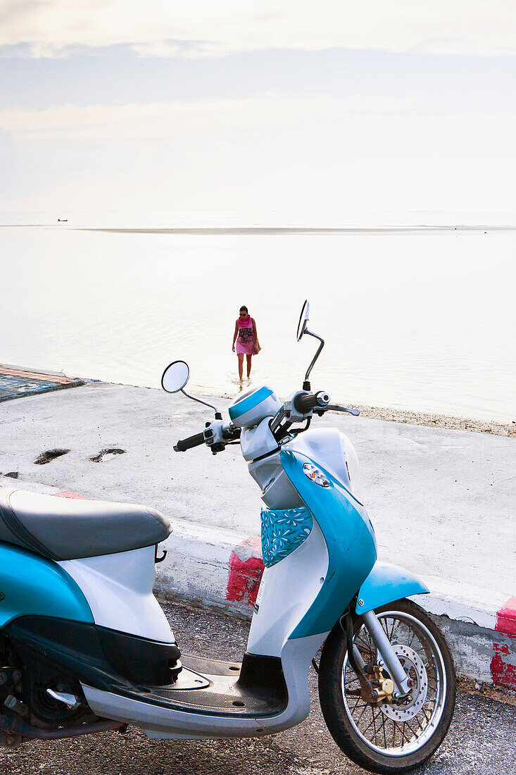 A motor scooter parked on the side of the road at the water's edge, Nathon Beach, Nathon, Ko Samui, Thailand