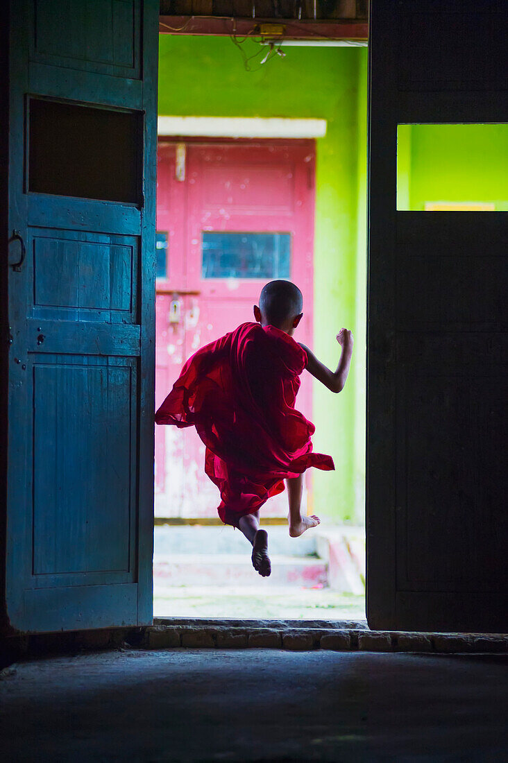 Young monk dances out of class, Yangoon, Myanmar