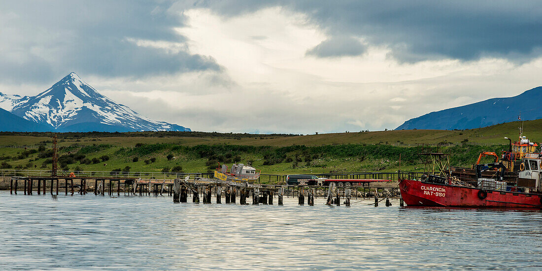 'A boat in the water with a mountain peak in the distance; Patagonia, Chile'