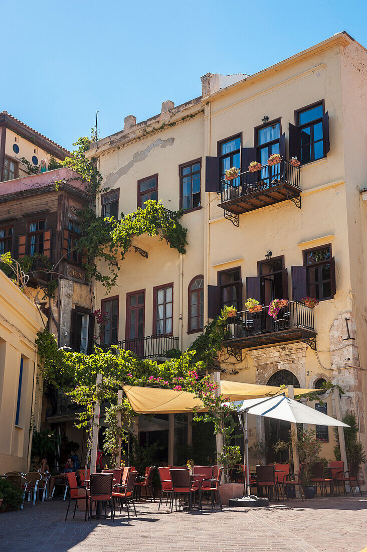 'Yellow residential building and restaurant patio; Chania, Crete, Greece'