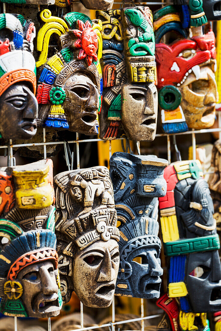 'Close up of colourfully painted Mayan masks hanging on display; Akumal, Quintana Roo, Mexico'