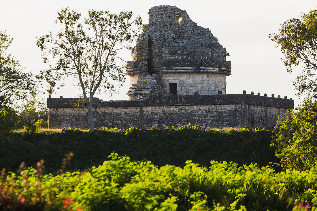 'Ancient Mayan Observatory with highlighted shrubs in the foreground; Chichen Itza, Yucatan, Mexico'