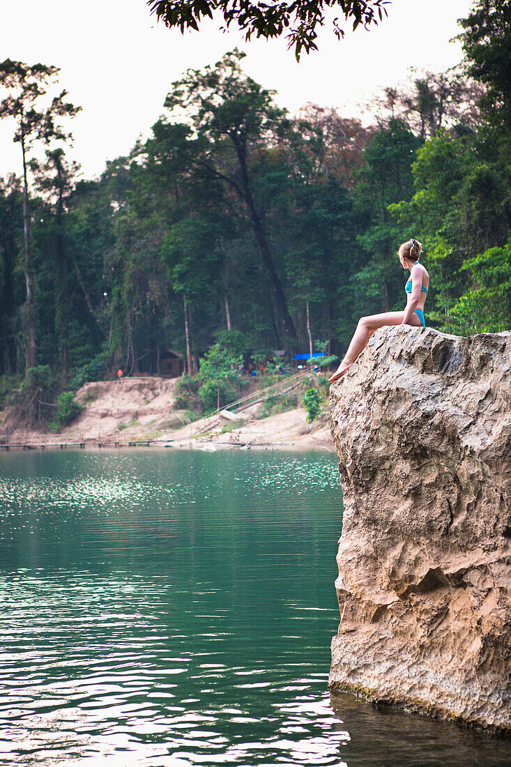 'A girl waits to jump from this cliff and swim outside the Seven kilometre caves; Kong Lor, Laos'