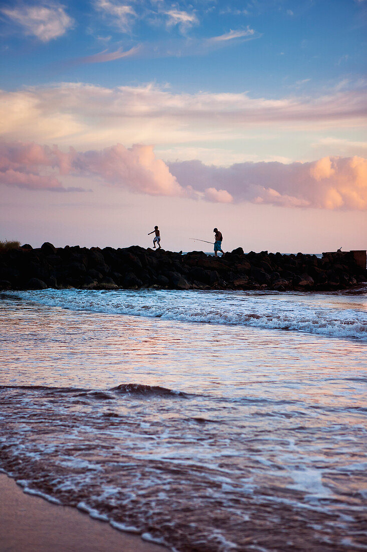 'A father and son fishing off the jetty at Pakala's; Kauai, Hawaii, United States of America'