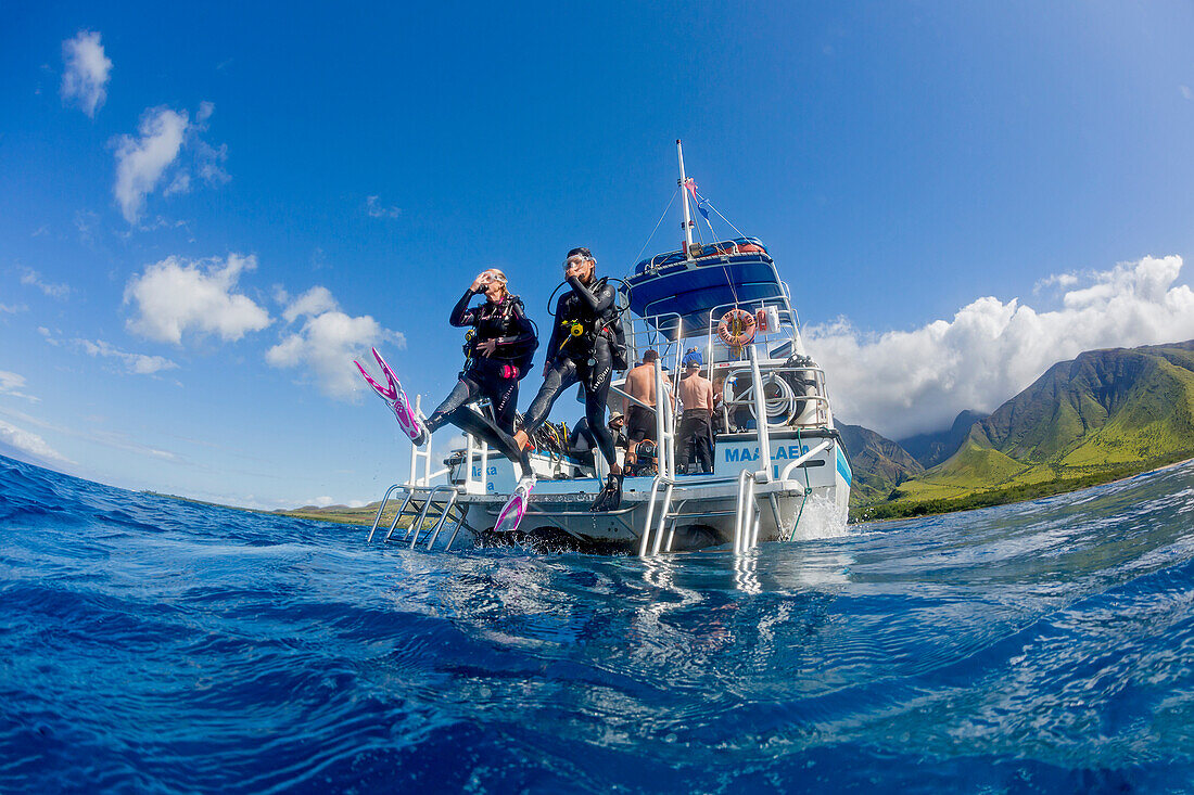 'Divers step off a dive boat into the Pacific Ocean out from Ukumehame; Maui, Hawaii, United States of America'