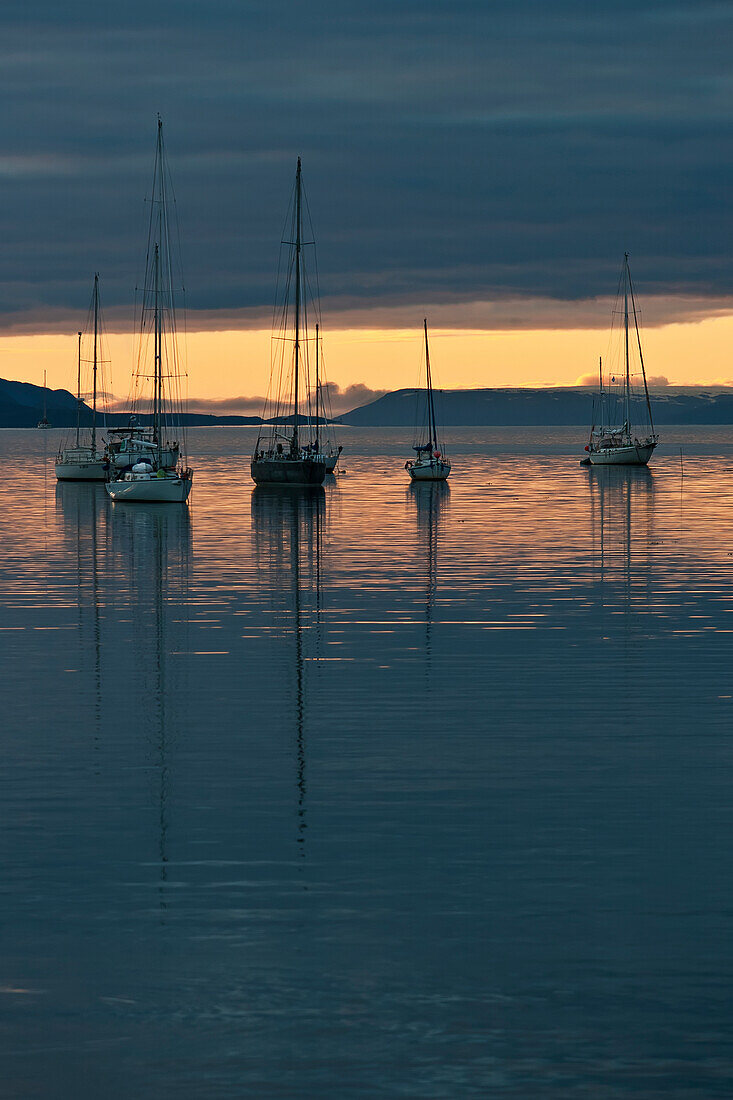 Sunset over the water with sailboats moored in the foreground, Ushuaia, Patagonia, Argentina