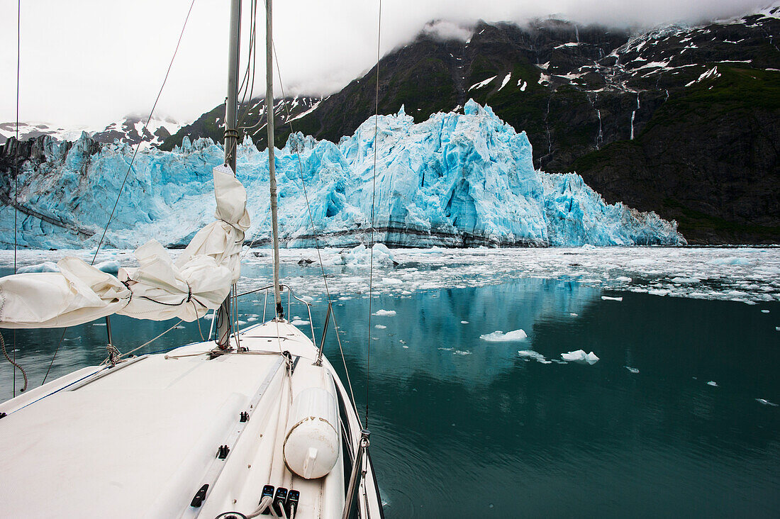 Sailboat in Prince William Sound with scenic view of tidewater glacier and mountains, Southcentral Alaska