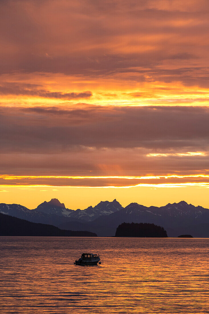 Scenic sunset view of Favorite Passage, Chilkat Mountains, and a silhouetted fishing boat, Inside Passage, Southeast Alaska