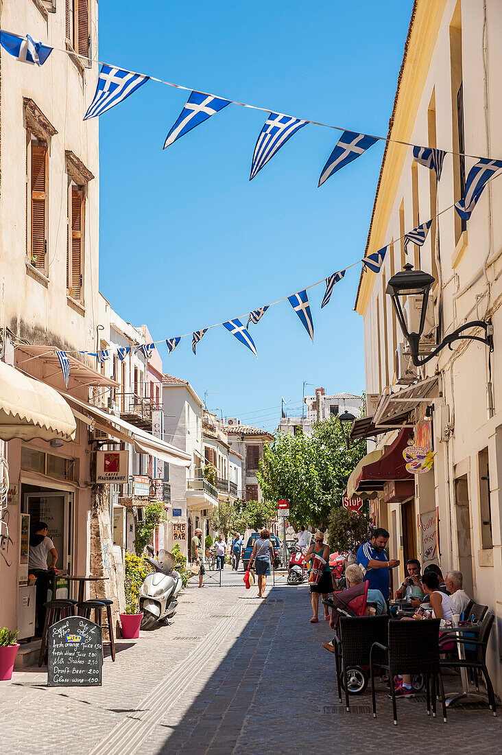 Flags hang over a narrow street, Chania, Crete, Greece