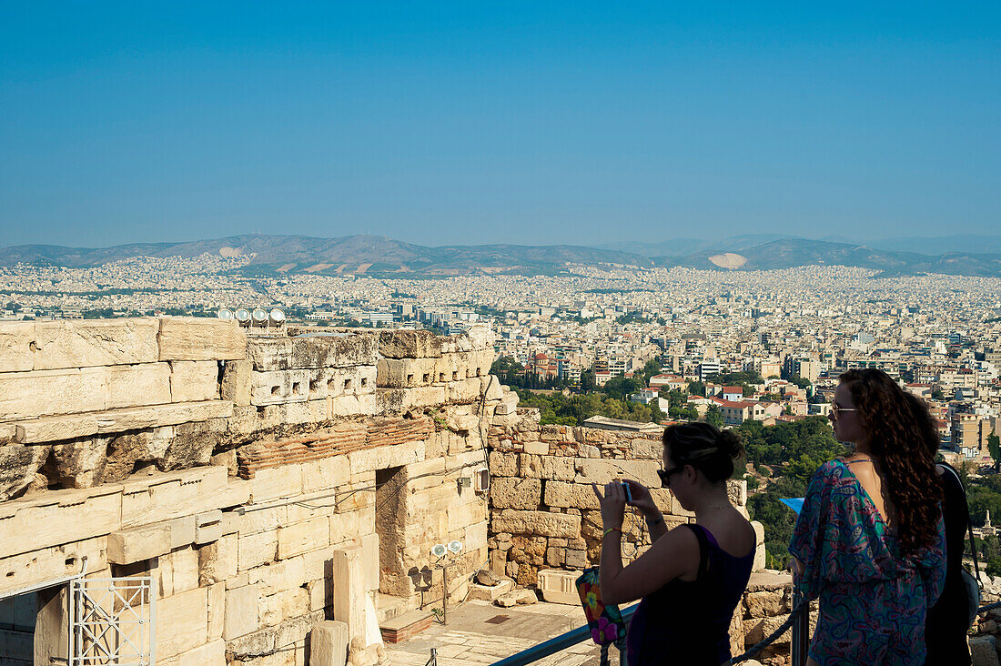 Tourists take pictures of ruins, view from the Acropolis, Athens, Greece
