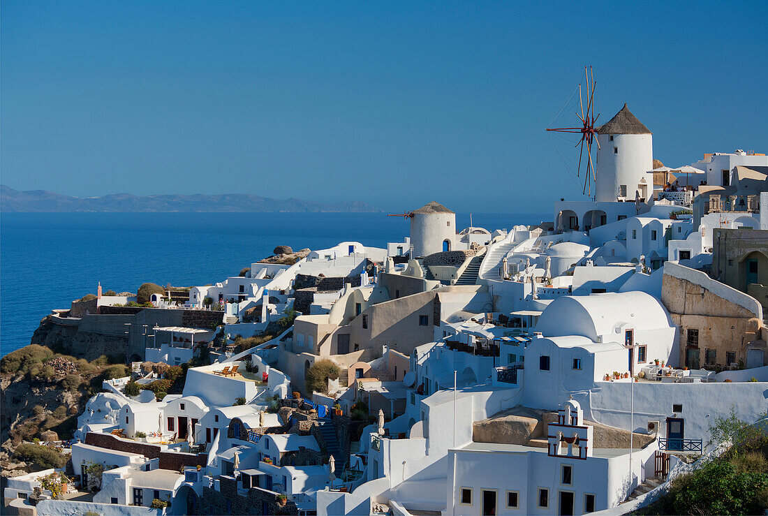 An old windmill above traditional painted houses, Oia, Santorini, Cyclades, Greek Islands, Greece