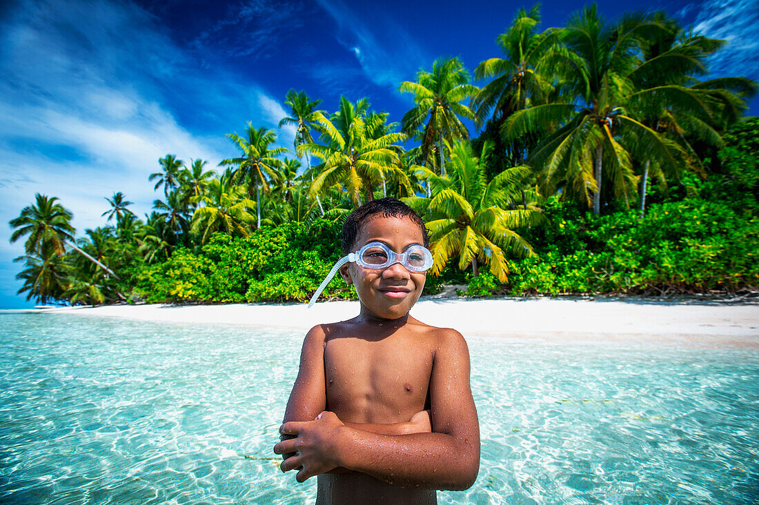 A Tuvalu boy wearing goggles on an island that forms part of a marine park just off the Tuvalu mainland, Tuvalu